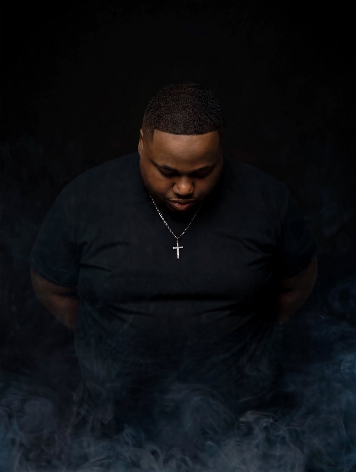 DJ Dough Boyy in a black shirt with smoke around him